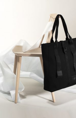 This image show the Angus Tote bag hanging on a chair.