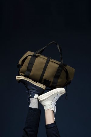 This image shows The James Weekend Bag, displayed on top of models feet.